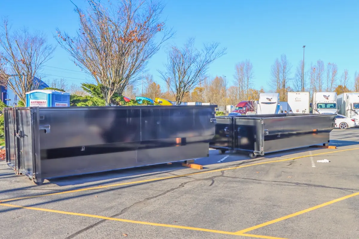 Professional dumpster rental service with roll-off container on residential driveway in Le Roy